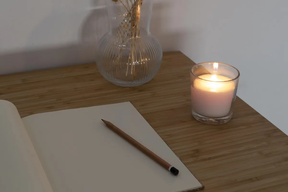 Notizbuch und Kerze als Symbol für Reflexion und Feedback